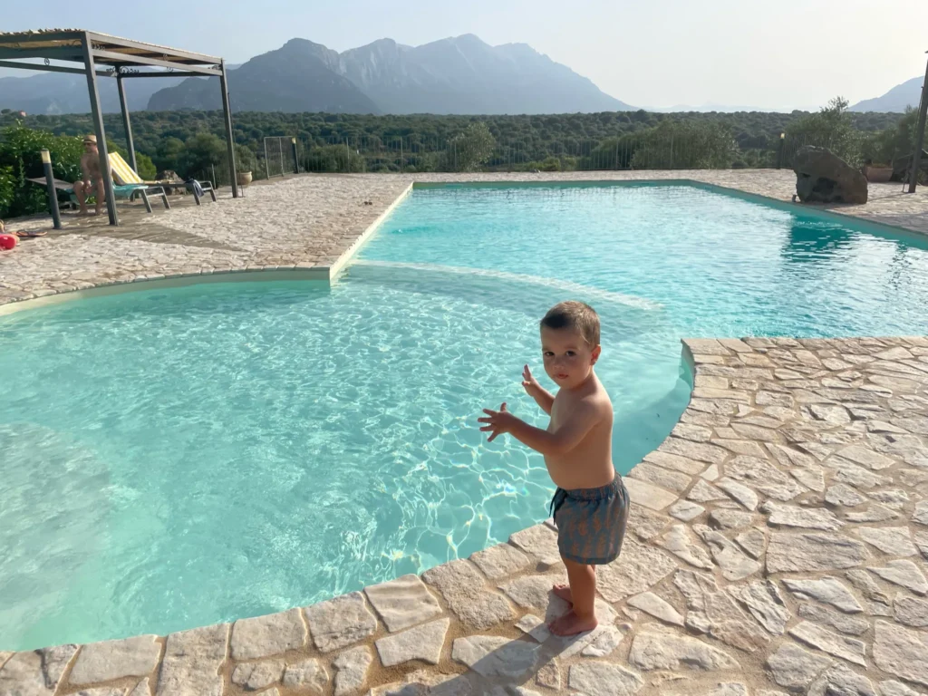 Niño pequeño disfrutando de la piscina del Agroturismo Muristene en Cala Gonone, uno de los alojamientos con encanto de nuestra ruta por Cerdeña en familia