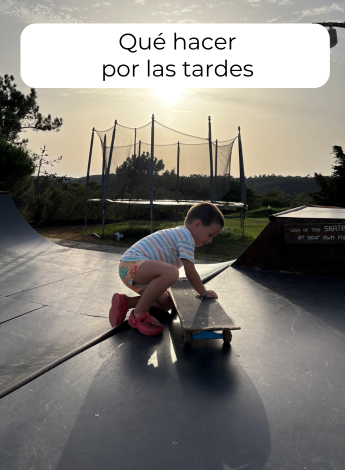 alt="Niño jugando con un monopatín en la rampa de skate del surfcamp al atardecer."