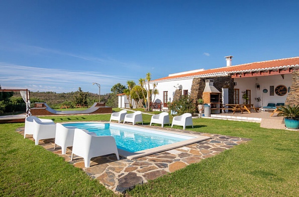 alt="Piscina y fachada blanca del Russo Surf Resort en Aljezur, Portugal."