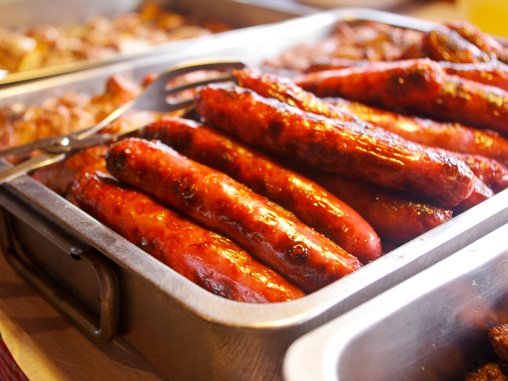 alt="Bandeja de salchichas a la brasa preparadas para la cena de barbacoa de los viernes"